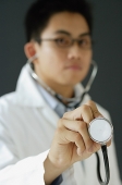 Doctor listening to stethoscope - Asia Images Group