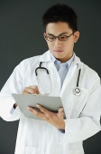 Doctor writing on clipboard - Asia Images Group