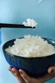 Woman holding bowl of rice and chopstick, close up - Asia Images Group