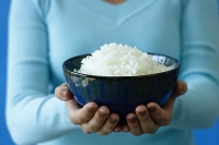 Woman holding bowl of rice, cropped image - Asia Images Group