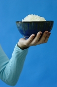 Woman holding bowl of rice in one hand - Asia Images Group