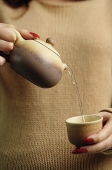 Woman pouring tea - Asia Images Group