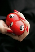 Womans hands with red nail polish, holding Yin Yang balls - Asia Images Group