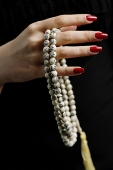 Womans hands holding prayer beads - Asia Images Group