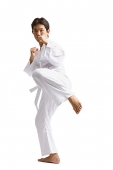 Young man practicing martial arts, preparing to kick - Asia Images Group