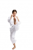 Young man doing martial arts, kicking - Asia Images Group