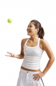 Young woman tossing tennis ball, hand on hip - Asia Images Group