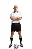 Young man wearing soccer uniform, standing with arms crossed - Asia Images Group