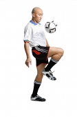 Young man in soccer uniform, using knee to hit ball - Asia Images Group