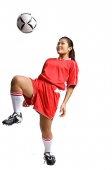 Young woman in soccer uniform, kneeing soccer ball - Asia Images Group