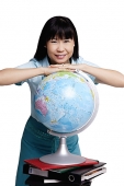 Woman leaning on globe, smiling - Asia Images Group