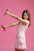 Woman dressed in pink, lifting dumbbell - Asia Images Group