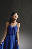 Woman in blue dress, eyes closed, smiling - Asia Images Group