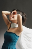 Woman wearing large sunglasses, tube top and scarf, smiling - Asia Images Group