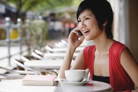 Woman at cafe using mobile phone - Asia Images Group
