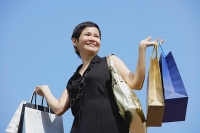 Mature woman carrying shopping bags, looking away - Asia Images Group