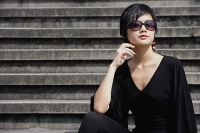 Woman dressed in black, wearing large sunglasses - Asia Images Group