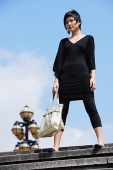 Woman dressed in black, standing on steps - Asia Images Group