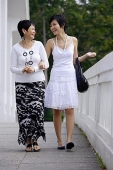 Women walking side by side, arm in arm - Asia Images Group
