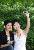 Women taking a picture with mobile phone - Asia Images Group