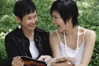 Two women with magazine - Asia Images Group