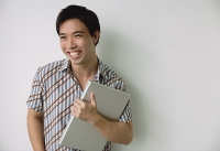 Man holding laptop, smiling - Asia Images Group