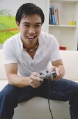 Man holding video game controller - Asia Images Group