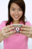 Woman holding Chinese tea cup towards camera, selective focus - Asia Images Group