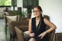Businesswoman sitting in patio, looking at camera - Asia Images Group