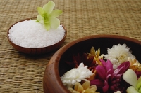Still life of flowers in bowl and a single flower head on bowl of rice - Asia Images Group