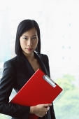Portrait of businesswoman, holding clipboard file - Asia Images Group