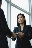 Businesswomen exchanging business cards - Asia Images Group
