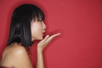 Woman with bob haircut, blowing a kiss, side view - Asia Images Group