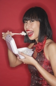 Woman eating rice from a Styrofoam container - Asia Images Group