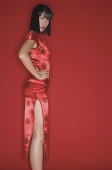 Woman wearing cheongsam and high heels, hand on hip, looking at camera - Asia Images Group