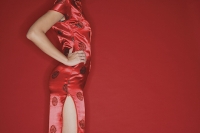 Woman in cheongsam, hands on hips, cropped - Asia Images Group