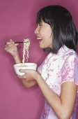 Woman eating noodles - Asia Images Group
