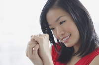 Woman looking at ring on her finger - Asia Images Group