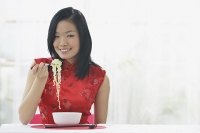 Woman eating bowl of noodles - Asia Images Group