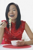 Woman eating noodles - Asia Images Group