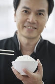 Man with bowl of rice and chopsticks - Asia Images Group