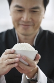 Man holding bowl of rice - Asia Images Group