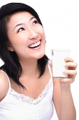 Young woman with glass of milk, looking up - Asia Images Group