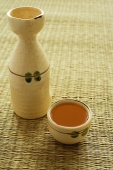 Ceramic bottle and cup with tea - Asia Images Group