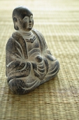 Still life of with small Buddha sculpture on mat - Asia Images Group