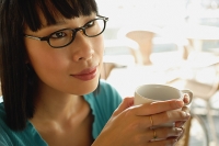 Young woman in black glasses, with coffee cup - Asia Images Group