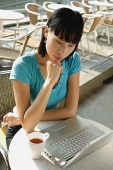 Young woman in cafe using laptop - Asia Images Group