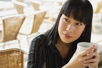 Businesswoman with cup, looking away - Asia Images Group