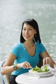 Young woman in cafe, having salad, looking away - Asia Images Group