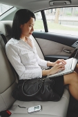 Businesswoman in car using laptop - Asia Images Group